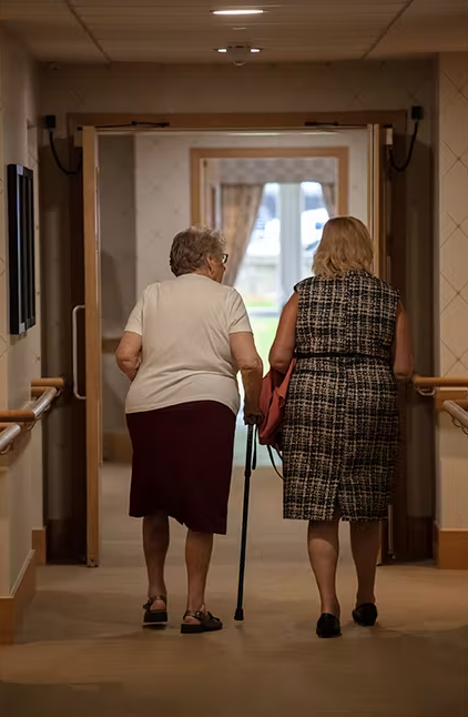 Two females walking together in the hallway.
