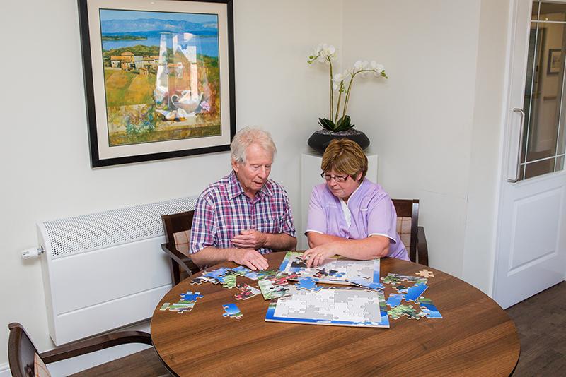 resident and staff member playing puzzle games