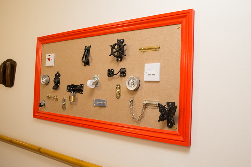 A framed sensory board with several hooks, light switches and locks.