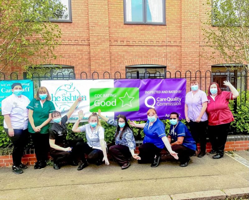 Several members of staff outside the home posing with the CQC "Good" rating sign.