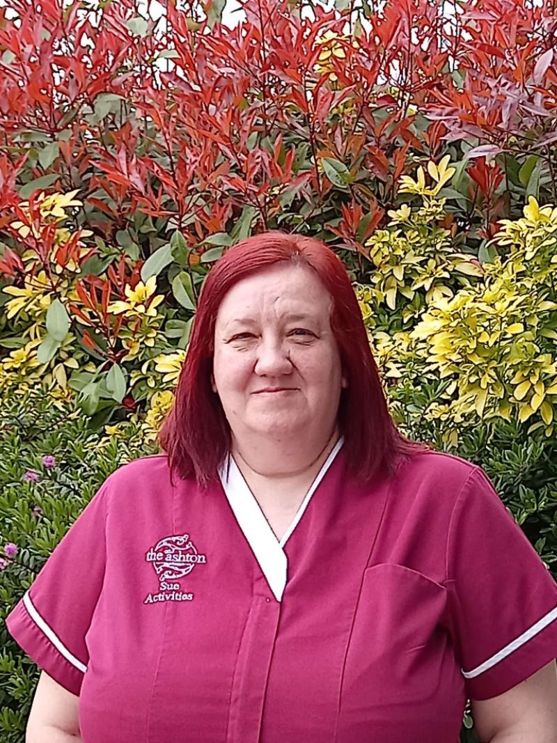 A carer in a red uniform with red hair.