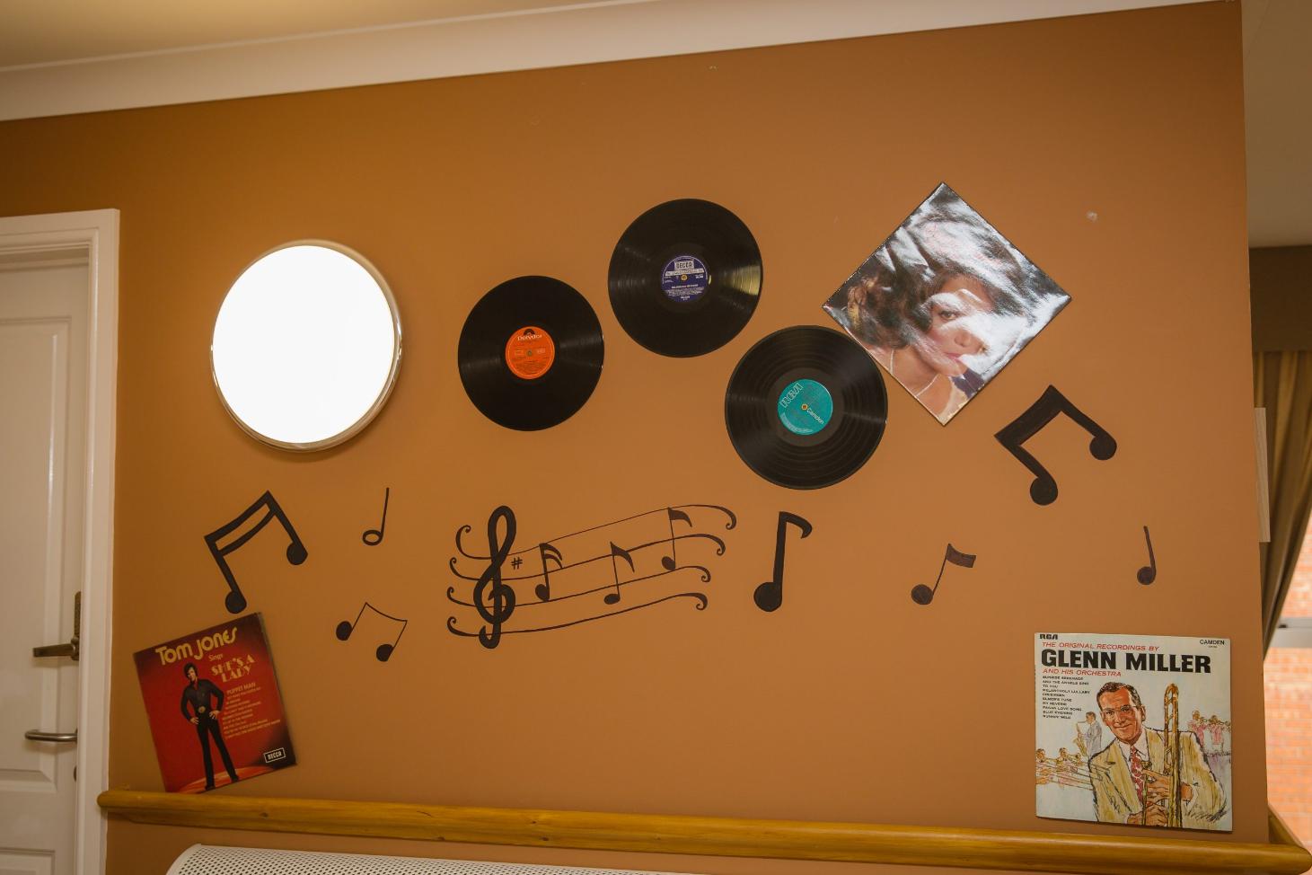 Orange wall decorated with music notes and vinyl records