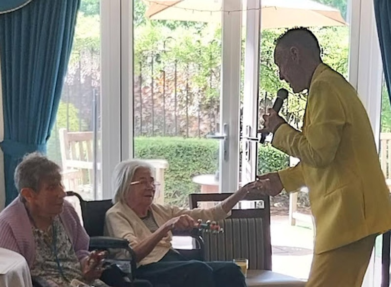 resident stood singing holding hands with one of our resident's