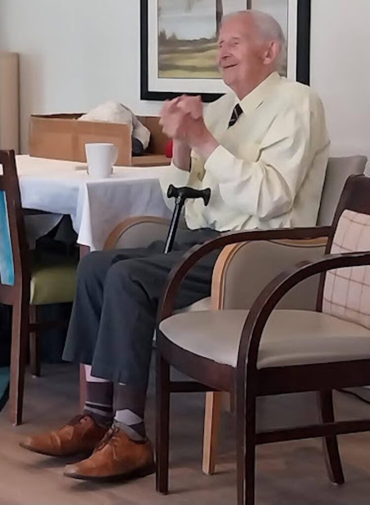 resident sat in chair smiling