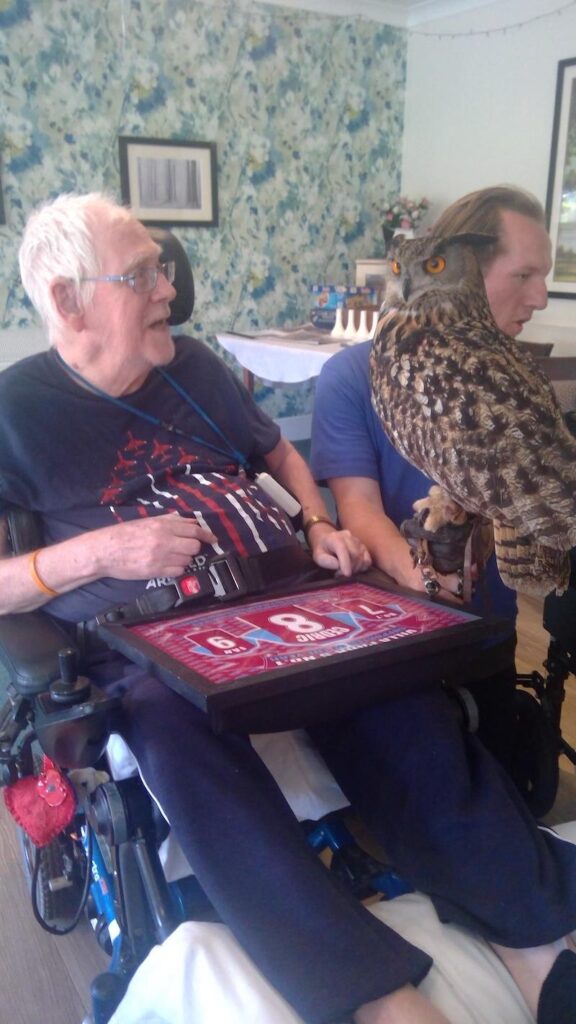 two male residents sat next to each other with an owl on their arm