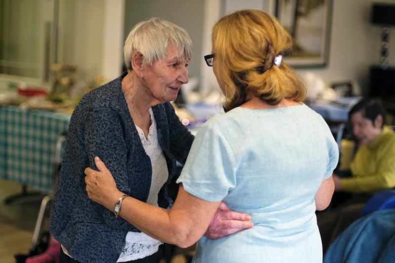 resident and carer dancing together