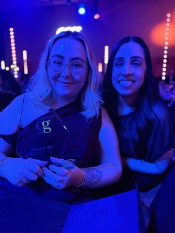 2 ladies smiling at the camera one holding an award