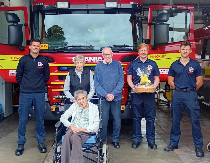 residents posing in front of fire engine with fire brigade